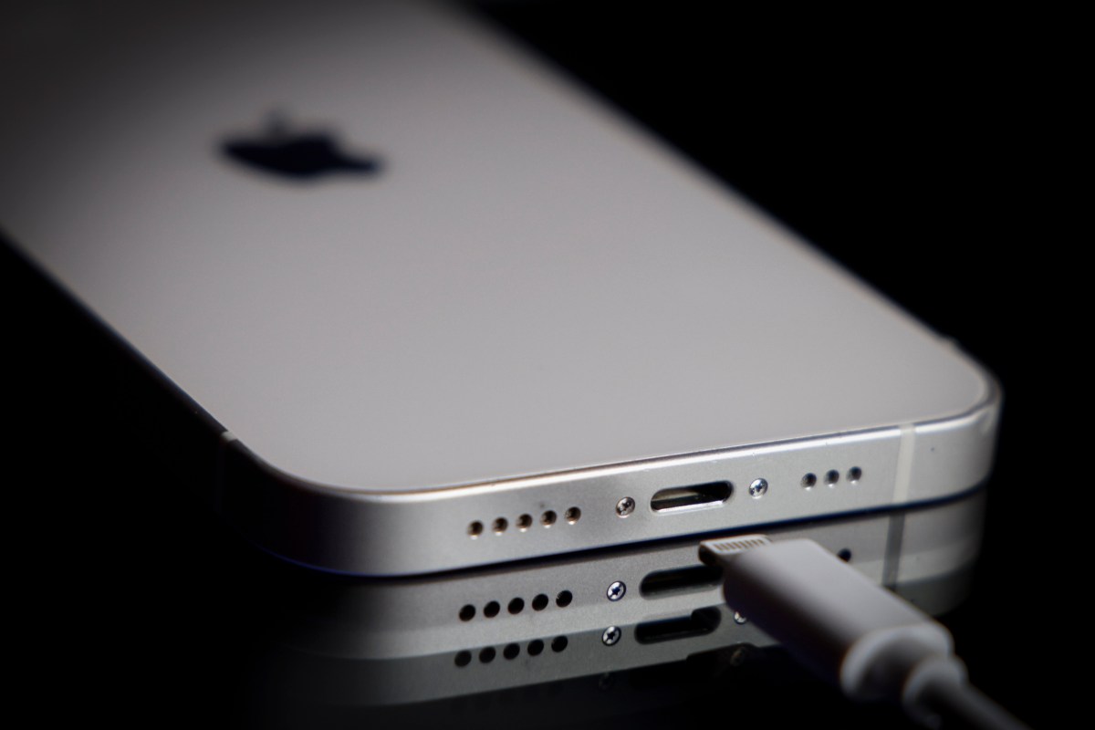 An iPhone connected to a USB charging cable